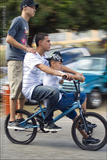 Three Kids on a Bike During San Blas Marathon Celebration in Coamo, Puerto Rico