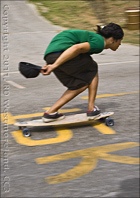 A boy surfs the road on a skateboard.